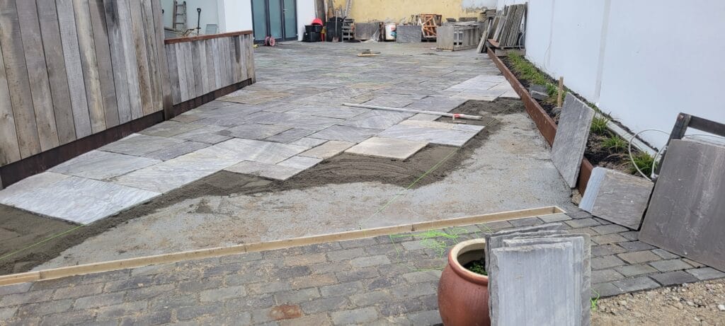 Belægningsarbejde med grå fliser på gårdsplads